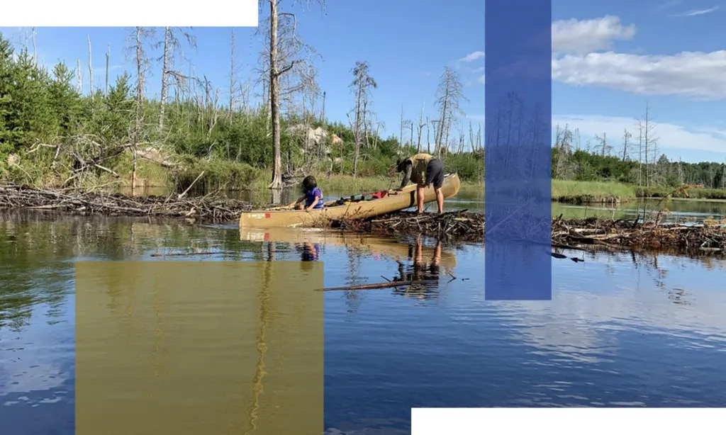 a man and boy get their canoe unstuck in the boundary waters