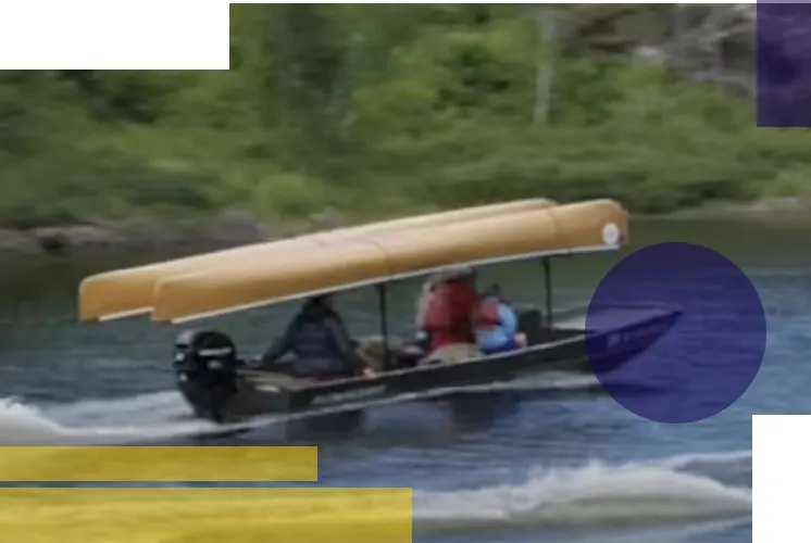a motor boat with two canoes mounted overhead driving on a lake